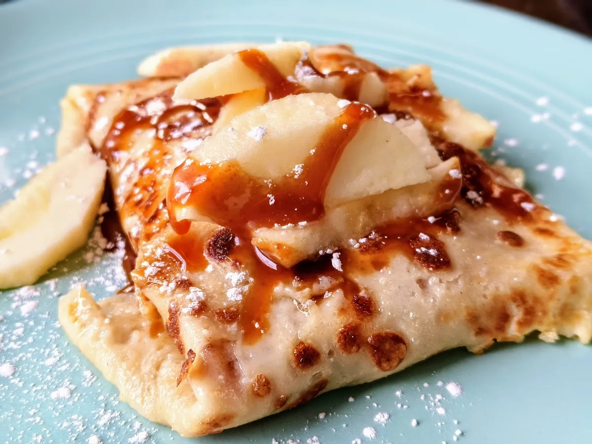 Crepe with apples, caramel, and powdered sugar