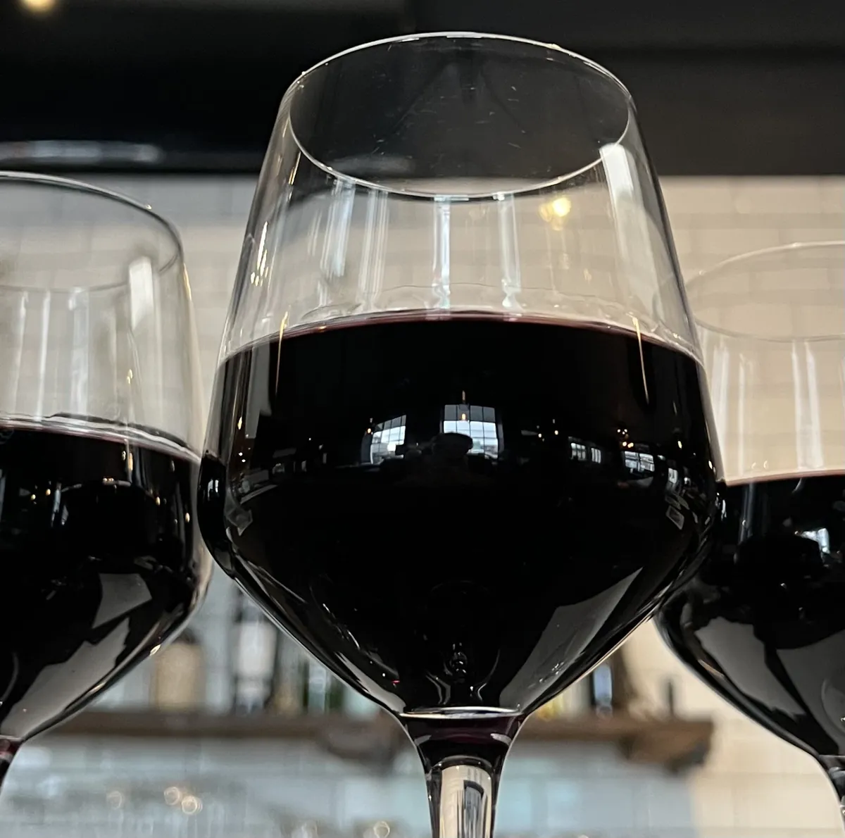 Three wine glasses filled with red wine